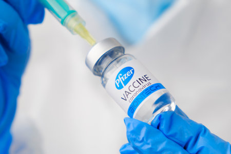 Pfizer coronavirus Vaccine and syringe in the bottle or vial for injection in doctors hands. Covid-19, SARS-Cov-2 prevention, January 2021, San Francisco, USA.のeditorial素材