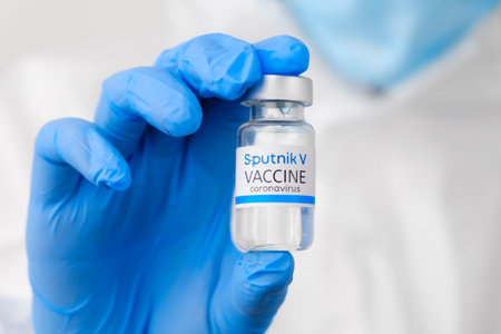 Sputnik V coronavirus vaccine in doctors or nurses hands in blue rubber gloves. Prevention of sars-cov-2 or Covid-19, January 2021, San Francisco, USAのeditorial素材