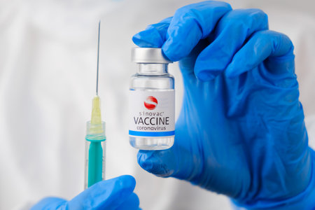 Sinovac vaccine and disposable syringe for injection in doctors hands. Prevention of coronavirus, Sars-cov-2, Covid-19, January 2021, San Francisco, USA.のeditorial素材