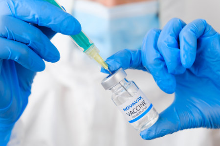 Novavax coronavirus Vaccine and syringe in the bottle or vial for injection in doctors hands. Covid-19, SARS-Cov-2 prevention, January 2021, San Francisco, USA.のeditorial素材