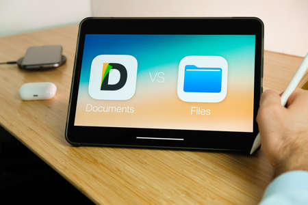 Apple Files vs Documents logo on the screen of iPad tablet. March 2021, San Francisco, USA