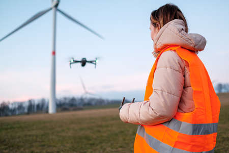 Technician engineer controls wind turbines using a drone. Production of green energy. Generation of power energy.の写真素材
