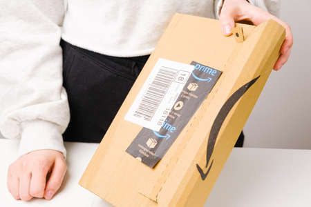 Close up woman hands opening a parcel from Amazon prime, March 2021, Prague, Czech Republicのeditorial素材