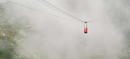 Red funicular or red suspension cable car to Lomnicky peak in fog or clouds, September 2020, High Tatry, Slovakiaのeditorial素材