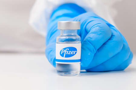 Pfizer vial or bottle with pharmaceuticals demonstrated by health worker or scientist in rubber gloves, April 2021, San Francisco, USAのeditorial素材