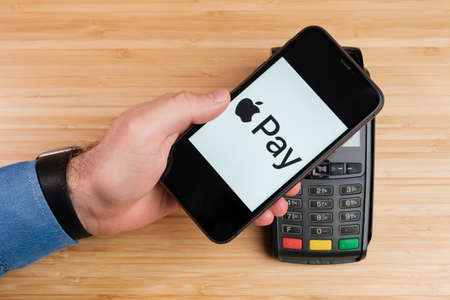 Apple Pay on the Iphone for payment using POS terminal. Contactless payment concept, April 2021, Prague, Czech Republicのeditorial素材