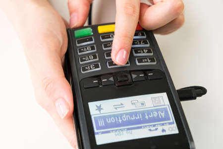 Alert irruption on the pos terminal in womans handの写真素材