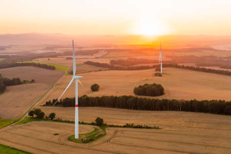 Panoramic view of windmills or wind turbines for electricity production at amazing sunset in the...