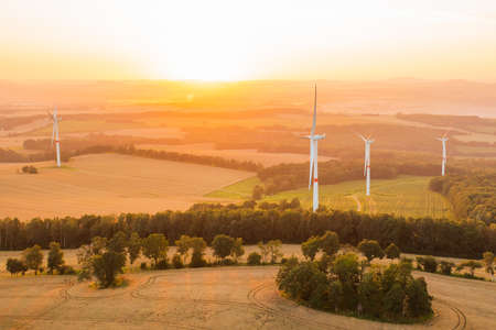 Panoramic view of windmills or wind turbines for electricity production at amazing sunset in the...