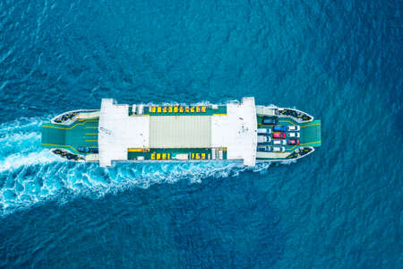 Top view on the ferry boat for car transportation on the blue water of the Adriatic sea. Automobiles...