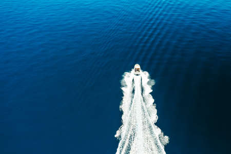 Top view of the boat or white yacht sails on the blue water of the Adriatic sea