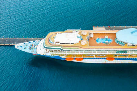 Aerial view of a luxury cruise ship or linear with a swimming pool on the roof moored in marina.の写真素材