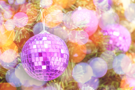 Christmas bokeh lights on a Christmas tree with purple balls background. New Year composition with copy spaceの写真素材