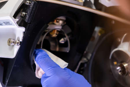 Cleaning of ion source of mass spectrometer by laboratory worker in rubber gloves. LC MS, liquid...
