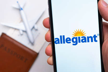 Allegiant airlines company app or logo displayed on a mobile phone with passport, boarding pass and plane on the background, September 2021, San Francisco, USAのeditorial素材