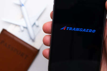 Transaero airlines company app or displayed on a mobile phone with passport, boarding pass, and plane on the background, September 2021, San Francisco, USA.のeditorial素材