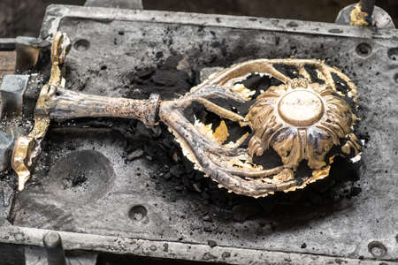 Stylish brass flower with branches in molding form cast in traditional way in ancient production plant workshop extreme close viewの写真素材