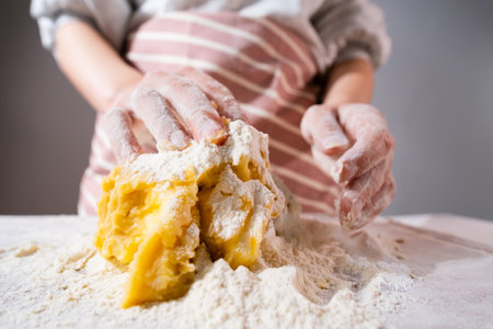Wide angle of woman hand kneading of dough for pizza, cookies, bins or gingerbreads on the wooden desk. Home made pastryの写真素材