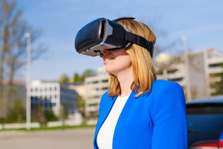 Woman with VR virtual reality goggles experiences a metaverse world. Augmented reality technology...