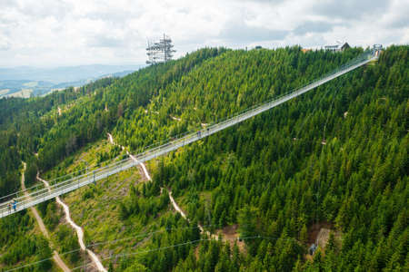 Aerial view of the worlds longest 721 meter suspension footbridge Sky bridge and observation tower the Sky walk in the forest, between mountains, Dolni Morava Ski Resort, Czech Republic.の写真素材