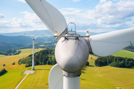 Close up a propeller of the windmill in the yellow field with mountains in the backgroundの写真素材
