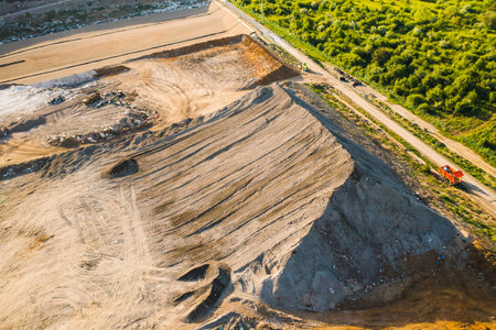 Quarry for mining of natural resources on the hill close to the forest, aerial viewの写真素材