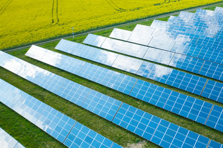 Long rows of sun panels built on green field. Innovative photovoltaic solar cells provide...