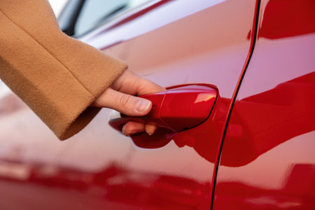 Woman opens the cars door by the hand, close up. Car sharing concept