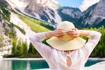 Backview of the woman enjoying the view of Dolomites Alps and Lake Braies.