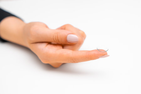 Disposable contact lenses in woman hands on the white backgroundの写真素材