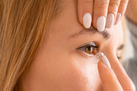 Side view of a happy woman applying contact eye lenses.の写真素材