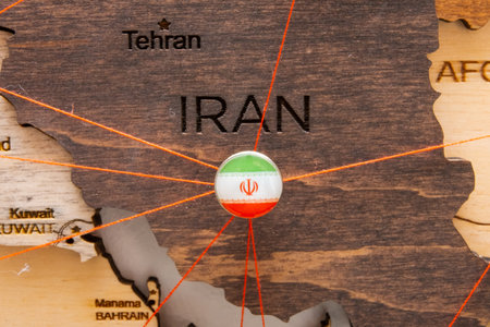 Iran flag on the pushpin and red threads on the wooden map. Travel or logistic routes. Influence in geopolitics and world economy.の写真素材