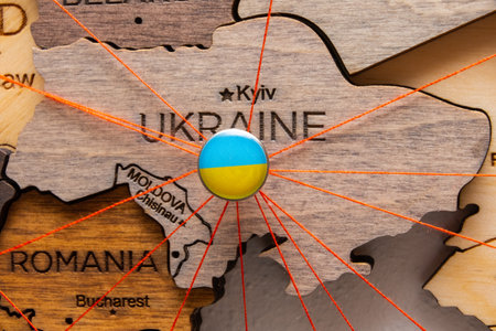 Ukraine flag pins and red thread for traveling and planning trips. Planning of logistics routes or spheres of influence in geopoliticsの写真素材