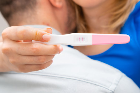 Woman hugging man and holding positive pregnancy test. Expect a baby concept.の写真素材