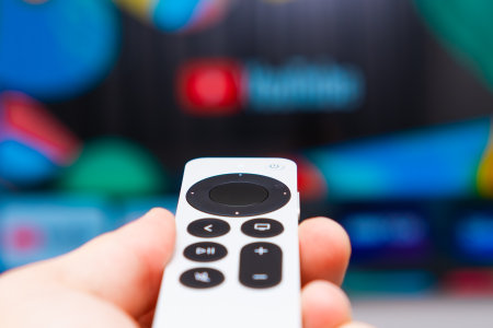 Youtube on Apple TV showing on the screen of TV. Man hands switch on television using remote controller, Fabruary 2023, Prague, Czech Republic.のeditorial素材