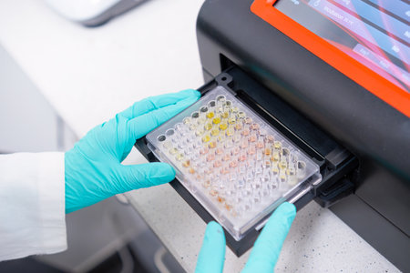 A microplate spectrophotometer is utilized by scientists to analyze DNA samples by inserting a microplateの写真素材