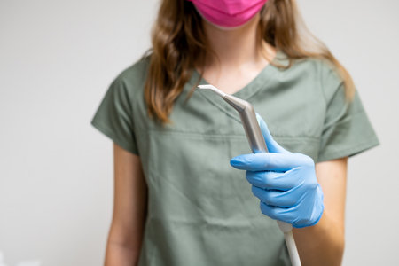 Dental brush in dentist hands in rubber gloves.の写真素材