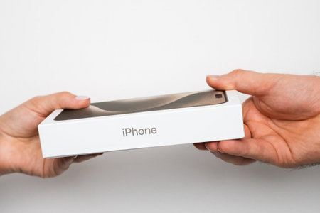 BERLIN , GERMANY - FEBRUARY 14 2024: IPhone boxes in womans and mans hands on the white background. Gift on the holiday.のeditorial素材