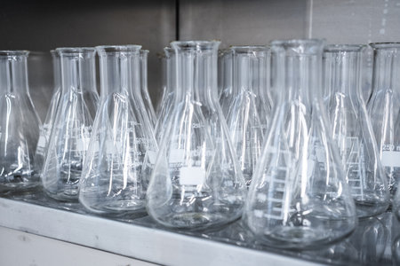 Empty conical Erlenmeyer flasks on the shelf ready for chemical analysis. Laboratory glassware.の写真素材