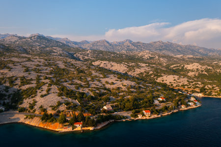 Serene coastal village in Croatia at sunset with hills in the background.の写真素材