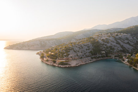 Breathtaking aerial view of a serene coastal landscape during golden hour near a tranquil bay.の写真素材