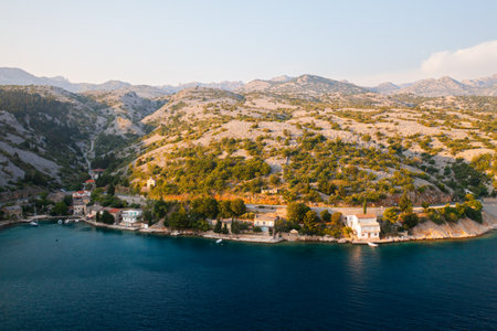 Coastal village nestled between mountains in early evening light.の写真素材
