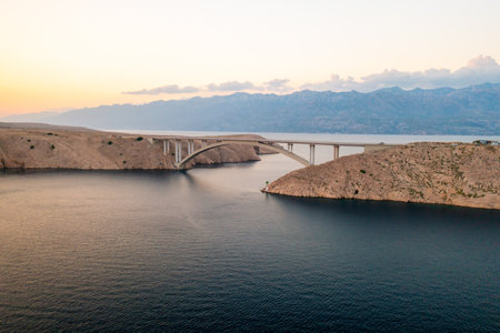 Pag Bridge with driving cars stretches over Adriatic sea lagoon. Infrastructure connects island with mainland offering quick navigation in Croatiaの写真素材