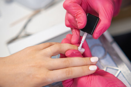 Application of gel polish at a nail salon by a professional technician on a clients hand.の写真素材