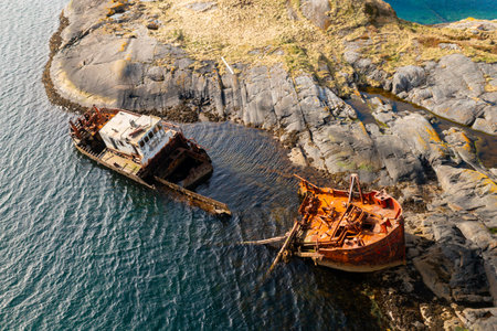 Wreckage of a sunken ship near rocky coastline in Norway, surrounded by cold northern waters and dramatic cliffs.の写真素材