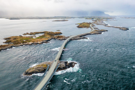Iconic Storseisundet Bridge on the Atlantic Ocean Road rising sharply above stormy waters, a masterpiece of Norwegian engineering. High quality photoの写真素材