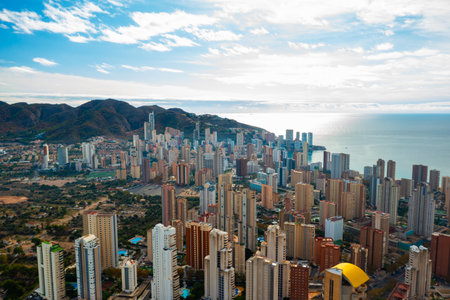 Breathtaking aerial panorama of Benidorm showing its famous high rise buildings, golden beaches, and calm blue waters of the Mediterranean. Sunny coastal resort city in southern Spain with skyline and modern architectureの写真素材