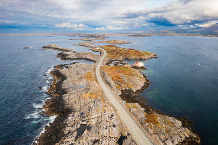 Magnificent Atlantic ocean road snakes across small islands and skerries. Grey sky and calm water emphasize vastness of Norwegian coastal landscapeの写真素材