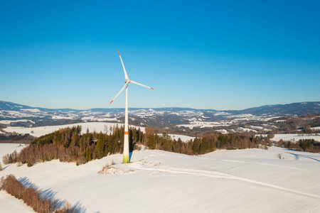 Wind turbine in a snowy field during winter. Concept of future energy transition and clean...
