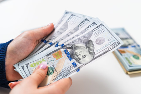 Close up of woman holding US dollar banknotes. Financial success and income concept.の写真素材